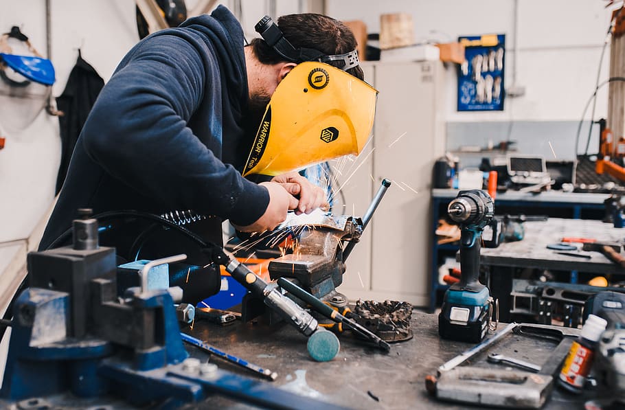 man wearing black hoodie using welding tool, work, spark, mask HD wallpaper
