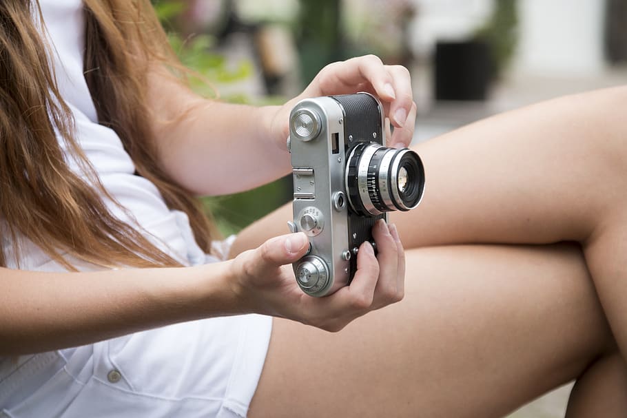 Woman Holding a Gray and Black Adjustable Lens Camera, hands HD wallpaper