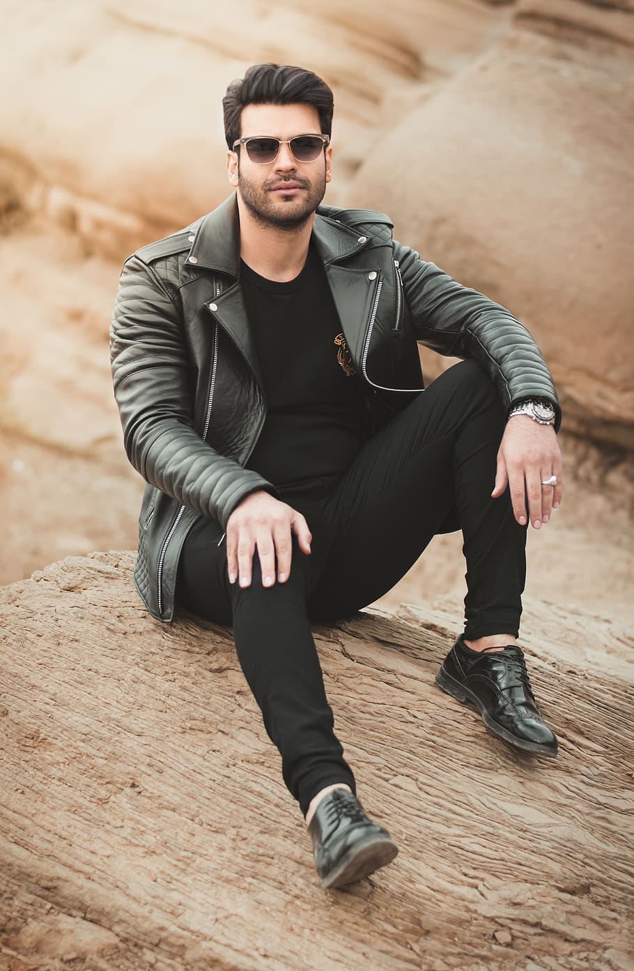 HD wallpaper man sitting on rock with black leather jacket during