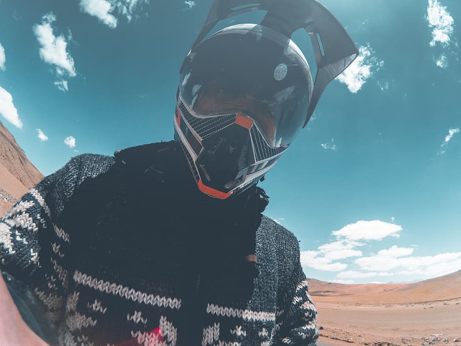 Closeup Photo of Man Wearing Black Racing Helmet Under Blue and White Sky HD wallpaper