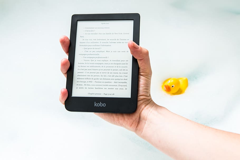 person holding turned on Amazon Kindle ebook reader, hand, diary