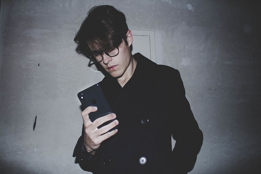 man wearing black jacket while holding iPhone X, person, human HD wallpaper