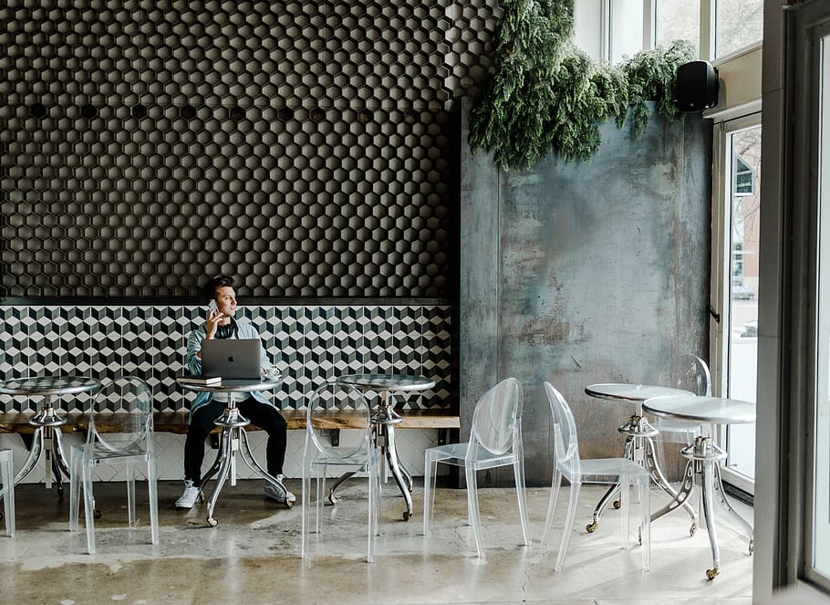 person sitting while using Macbook inside the building, chair HD wallpaper