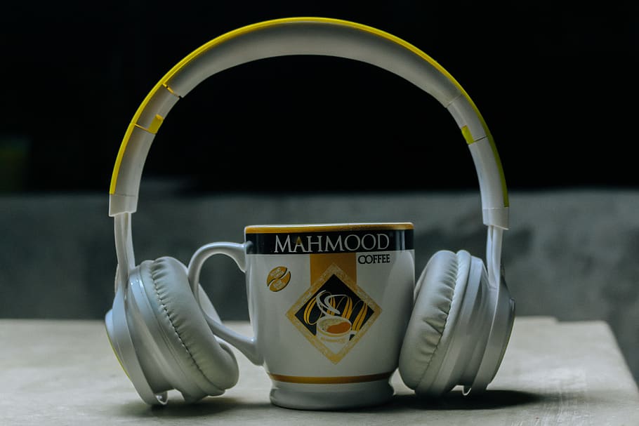 Close-Up Photography of Headset Near Cup, blur, coffee cup, depth of field HD wallpaper