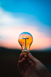 person holding bulb, light, orange, sky, blue, hand, bokeh, blur HD wallpaper