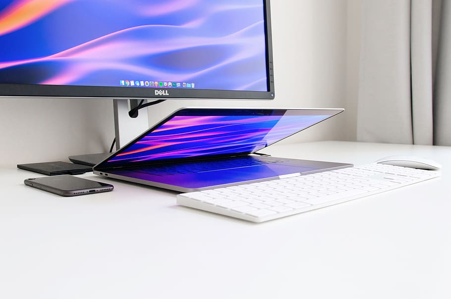 turned-on Dell monitor at table in front of laptop, keyboard, and mouse HD wallpaper