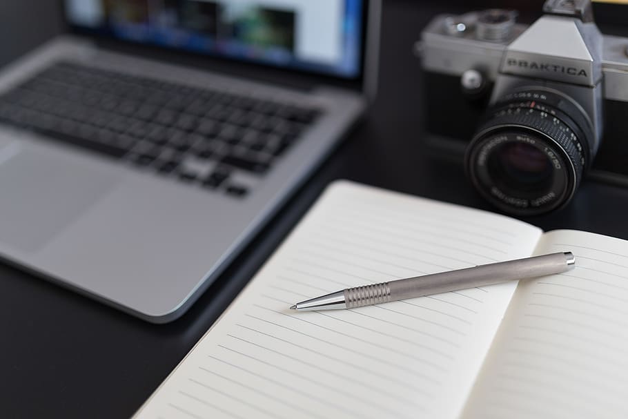 Black and Gray Dslr Camera Beside Macbook Pro, laptop, notebook HD wallpaper