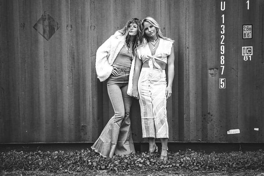 Grayscale Photo of Women Posing Against Shipping Container, beautiful women