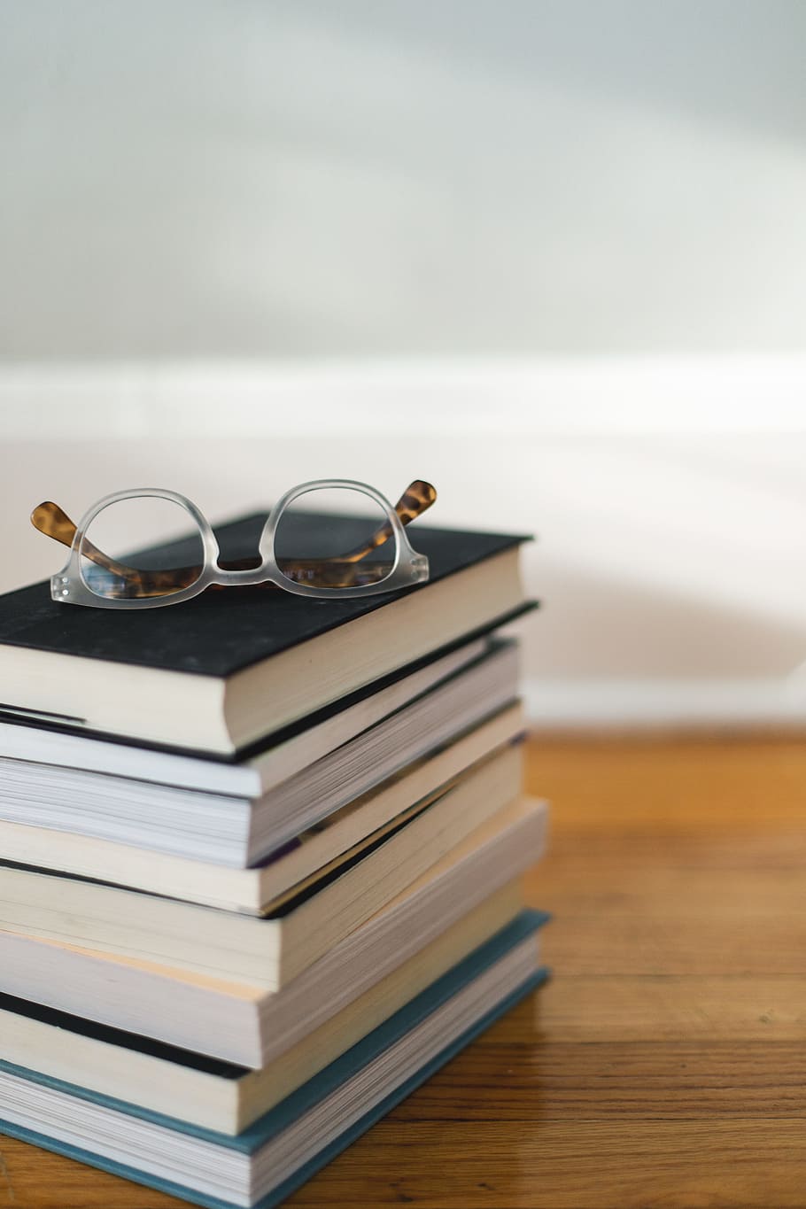 clear framed eyeglasses on top of pile of books, stack, bokeh HD wallpaper