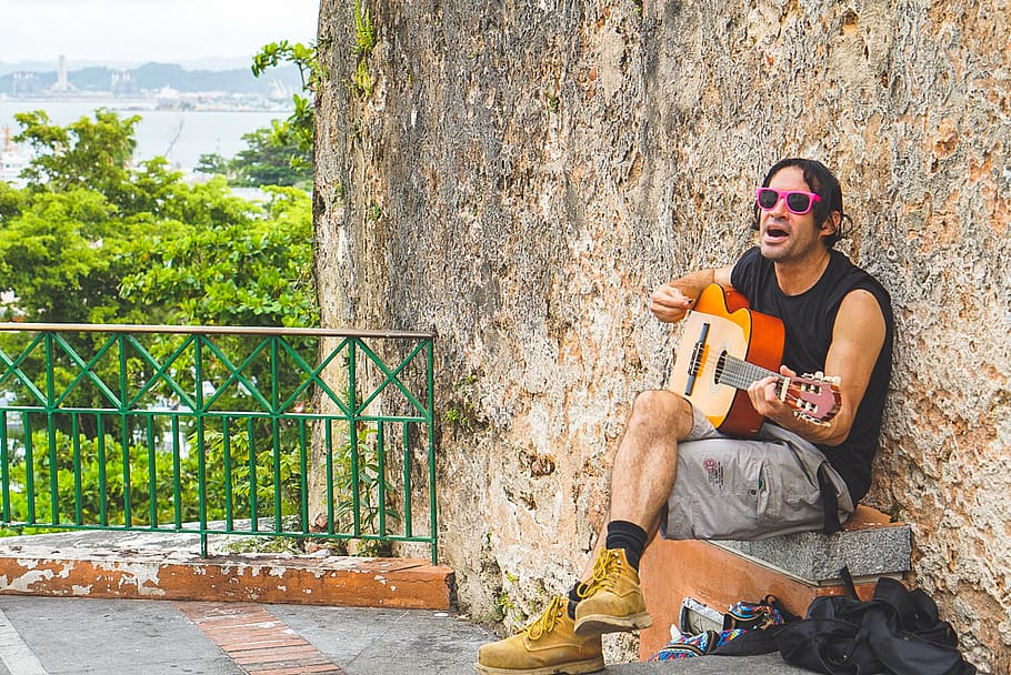 man playing guitar during daytime, person, human, apparel, clothing