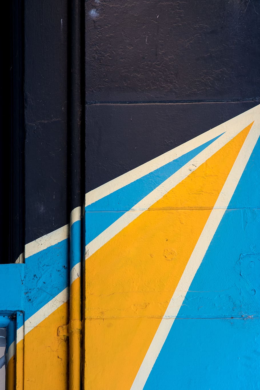white, blue, and yellow mural painted on building wall, art, pipe