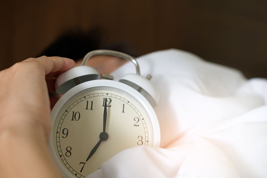 Photo of Person Holding Alarm Clock, adult, bed, blur, close-up