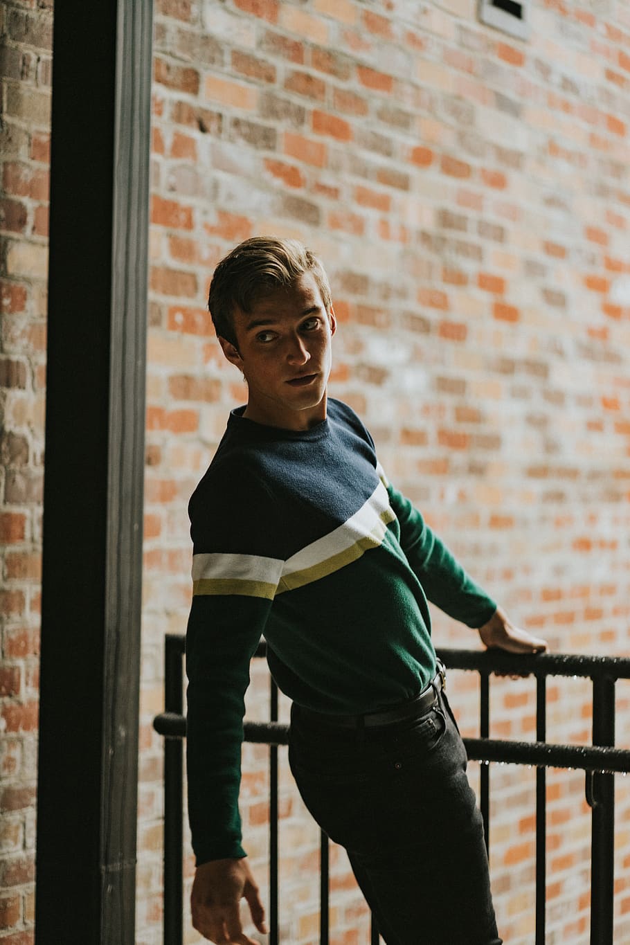 man in sweater holding handrails while looking back, one person HD wallpaper