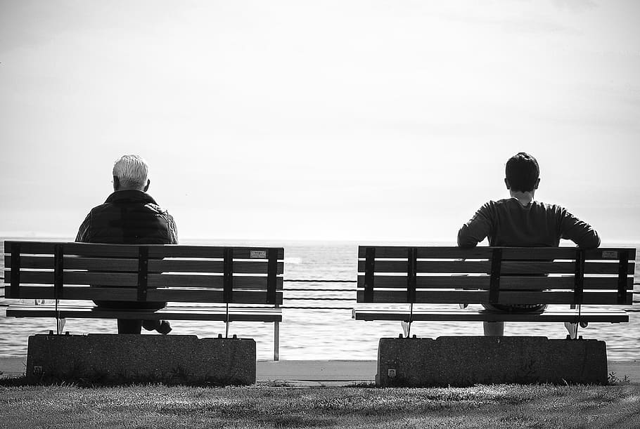 Grayscale Photo 2 Person Sitting in a Separate Benches on the Seaside HD wallpaper
