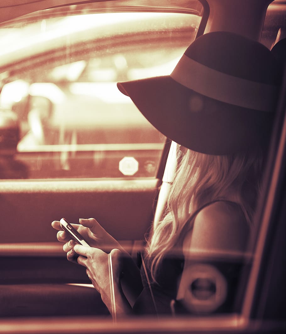 Девушка сидит в чулках в машине. Девушка сидит в машине и смотрит на телефон. Hat car