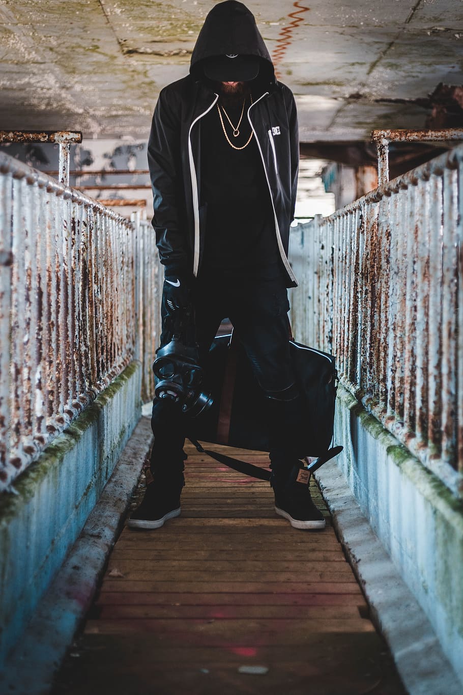 man standing in middle of bridge while holding bag, street, streetwear