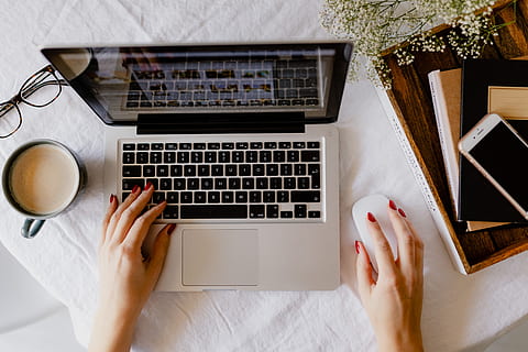 A woman works at a desk with a laptop and a cup of coffee, macbook HD wallpaper