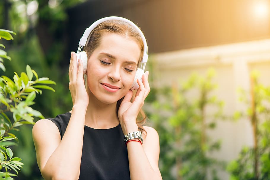 Woman Wearing Black Sleeveless Dress Holding White Headphone at Daytime HD wallpaper
