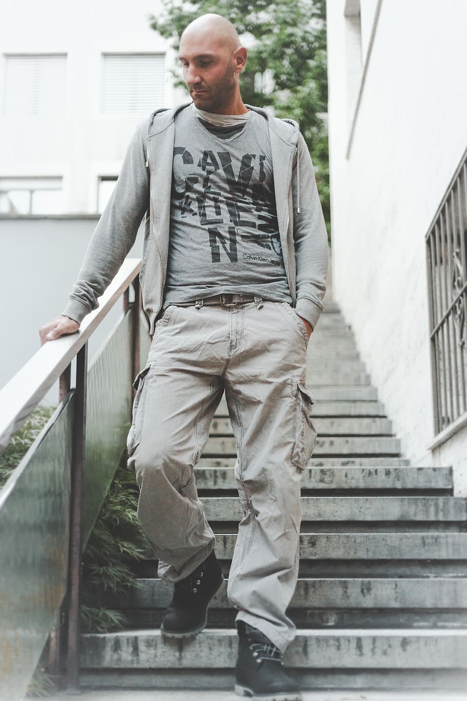 Photo of Man Wearing Grey Zip-up Jacket and Brown Cargo Pants Walking Down on Concrete Stairs, HD wallpaper
