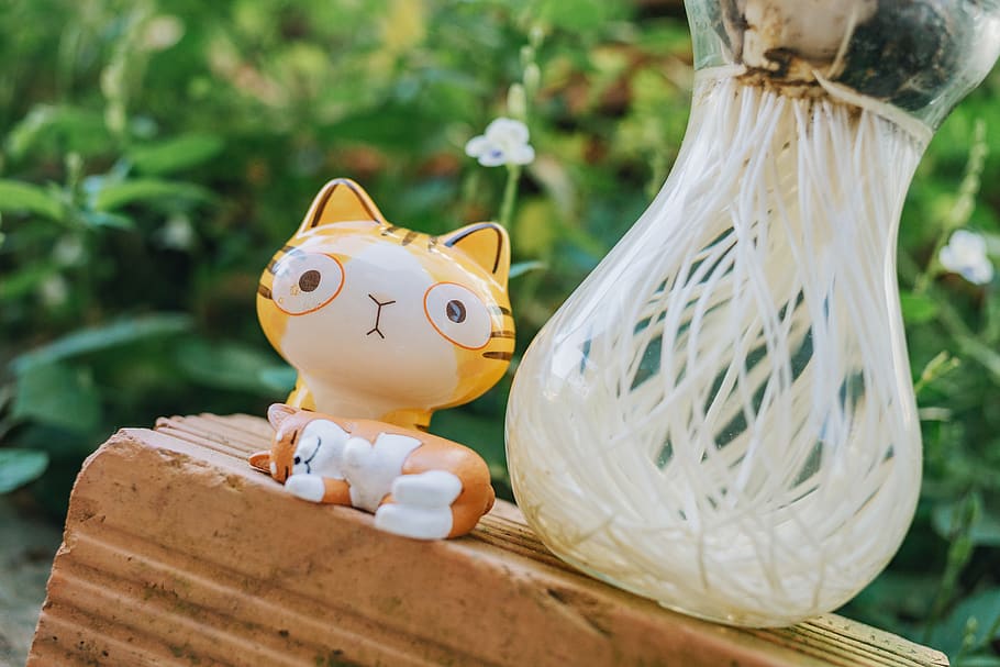 Yellow Cat Figurine Beside Clear Glass Vase, ceramic, close-up HD wallpaper