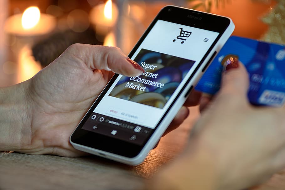 Person Using Black And White Smartphone and Holding Blue Card HD wallpaper