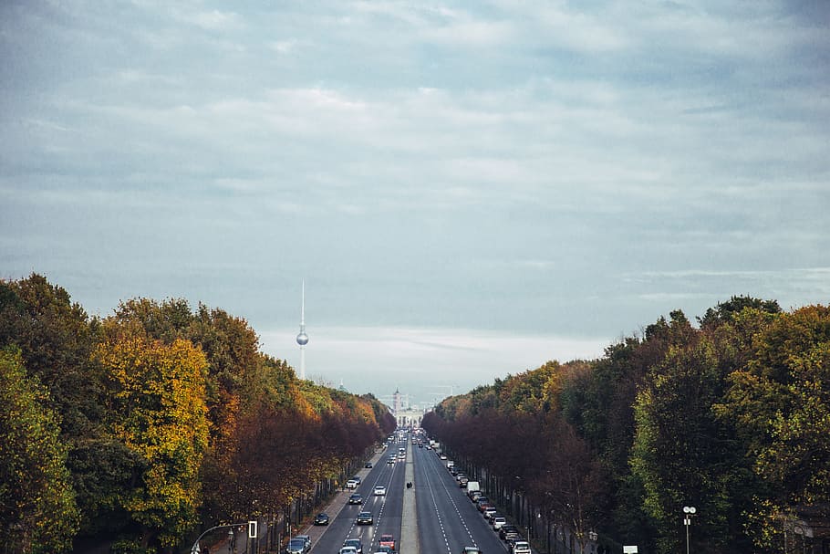 City in the backdrop of a fall forest highway with cloudscape HD wallpaper