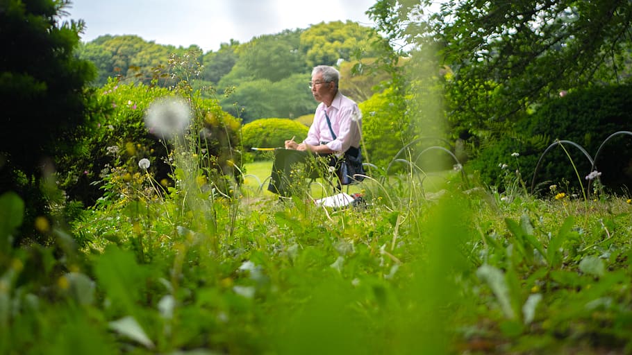man writing while sitting on green grass, person, human, outdoors HD wallpaper