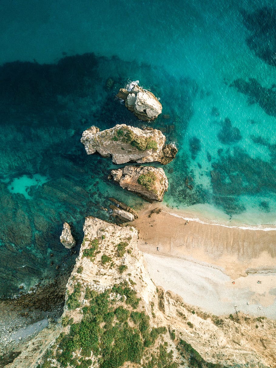 aerial view of body of water, rock, island, shore, coast, beach