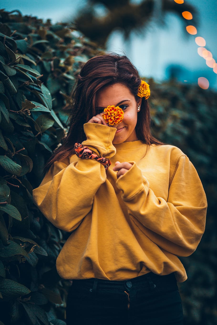 HD wallpaper: woman holding marigold flower by her face, one person