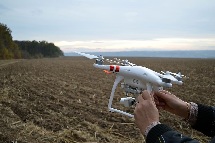 Person Holding Dji Phantom 3 Quadcopter Drone at Open Field, close-up HD wallpaper