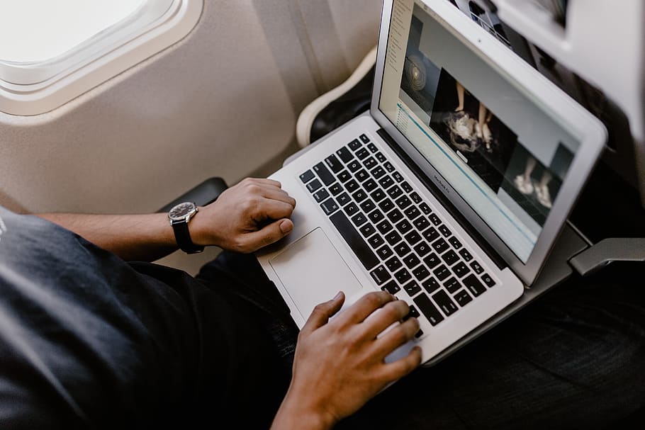 Unrecognizable man with notebook sitting inside an airplane, adult HD wallpaper