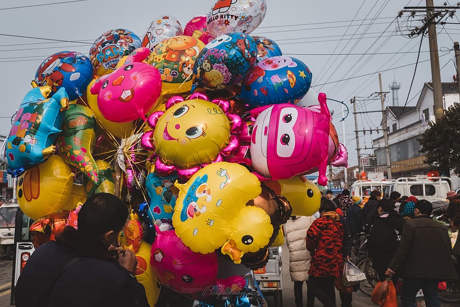 man holding assorted balloons, multi colored, group of people HD wallpaper