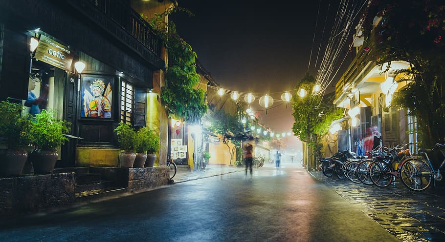 Person Standing on Gray Path Way Near Bicycles during Night Time HD wallpaper