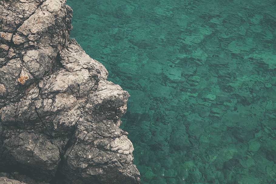 Brown and Gray Rock Formation Beside Calm Body of Water at Daytime HD wallpaper