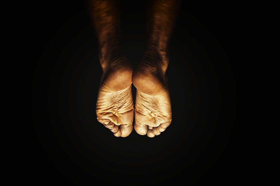 Two sockless feet surrounded by darkness., human body part, human hand HD wallpaper
