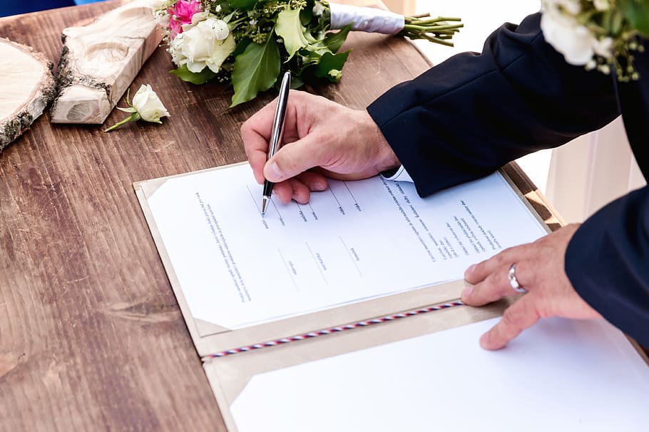Wedding ceremony. Wedding couple leaving their signatures, hand HD wallpaper