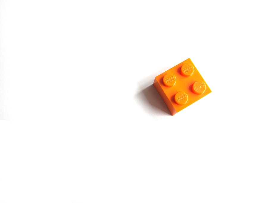 A single orange Lego piece., blocks, artist, create, possibility