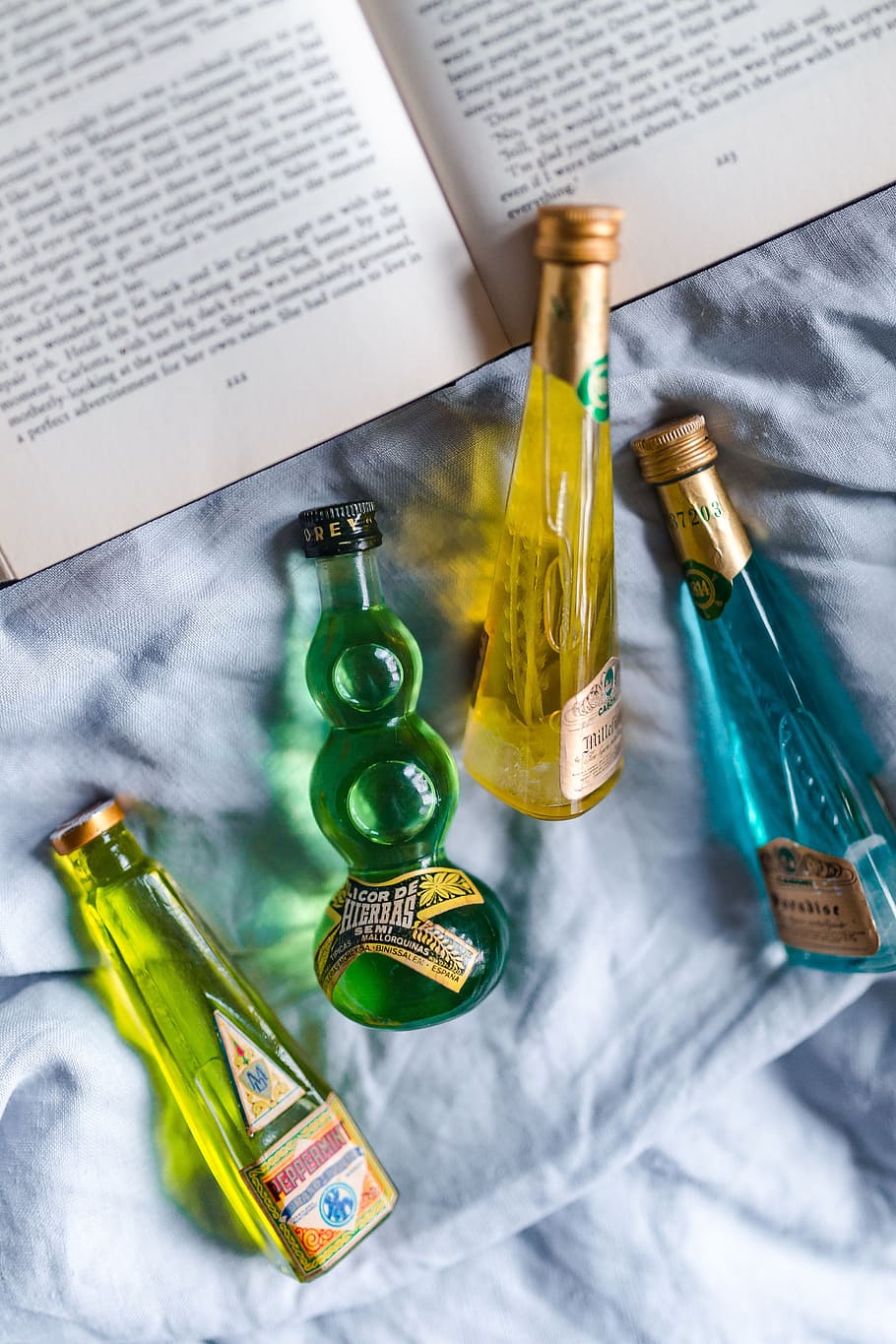 Group of colorful little bottles with liqueurs, book, drink, read HD wallpaper