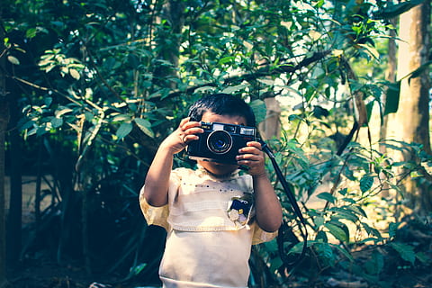 Boy Holding Black Flash Camera Near Green Leaf Plants, child HD wallpaper
