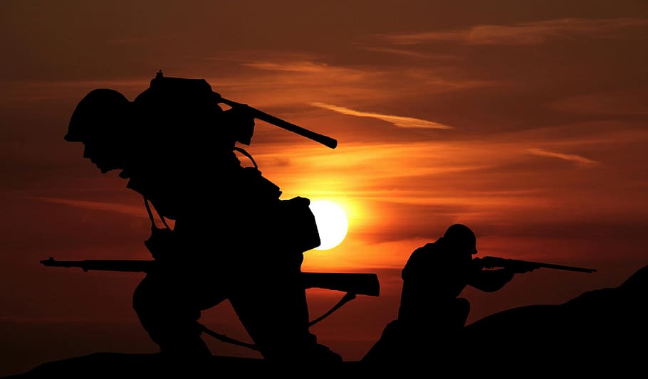 Silhouettes of soldiers against sunset of battlefield., war, army