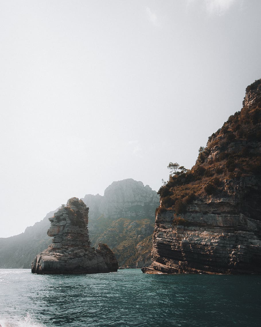 island under gray sky, rock, beauty in nature, sea, rock - object HD wallpaper
