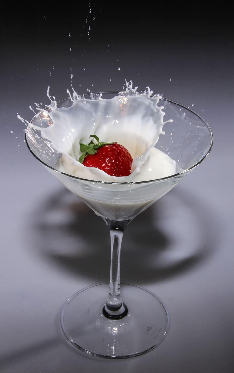 Clear Long Stem Wine Glass With Strawberry and White Liquid, cocktail