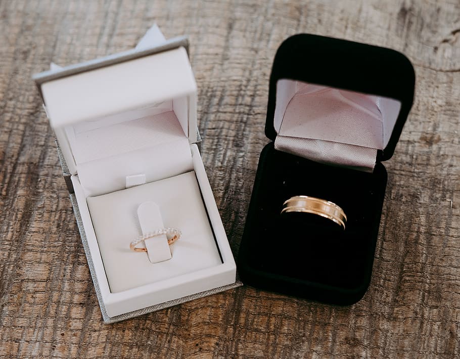 two gold-colored rings inside cases place on brown surface, married HD wallpaper
