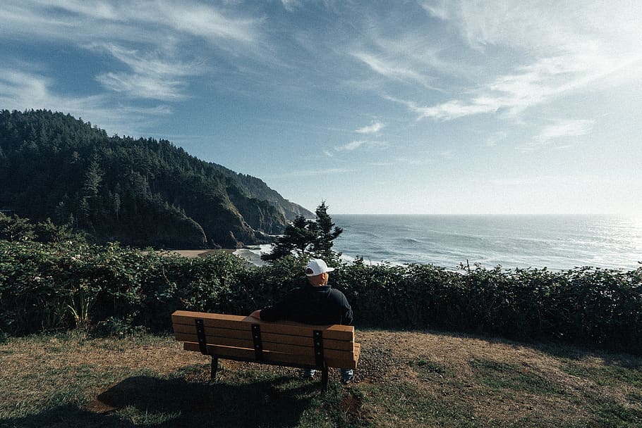 man sitting on bench with mountain background, sky, one person HD wallpaper