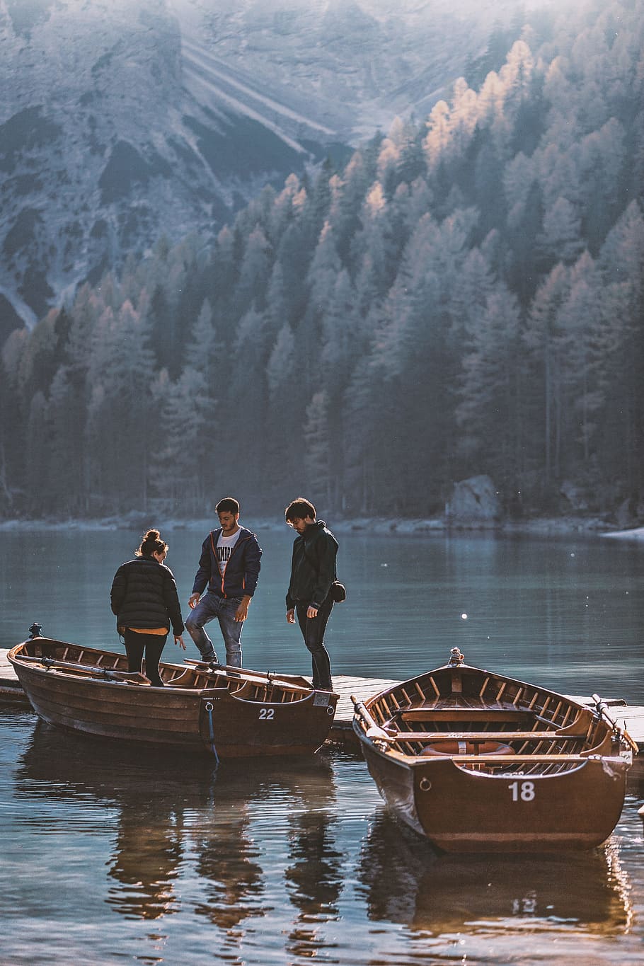 three person in dock near the boat during daytime, mountain, tree HD wallpaper