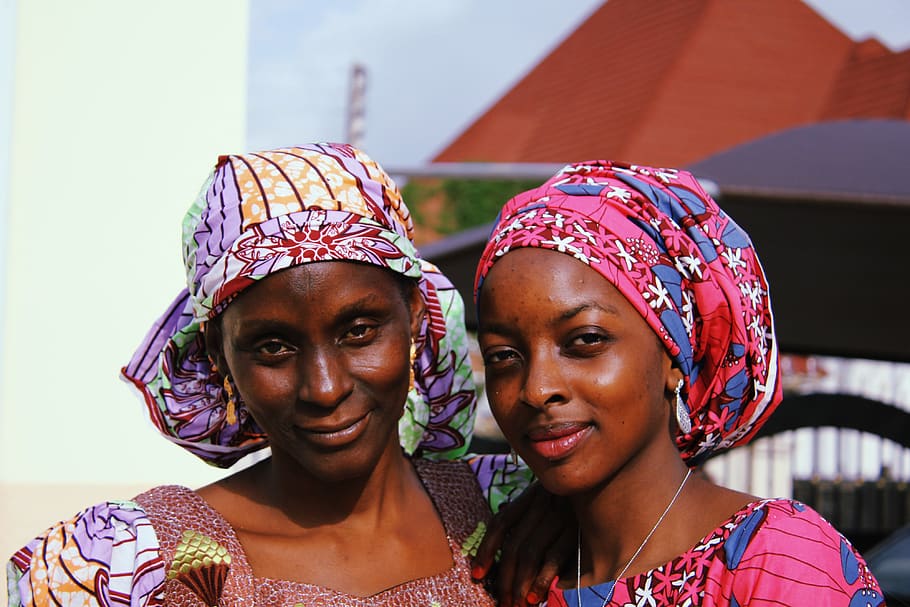 Two Women in Traditional Dresses Posing for Photo, african wear