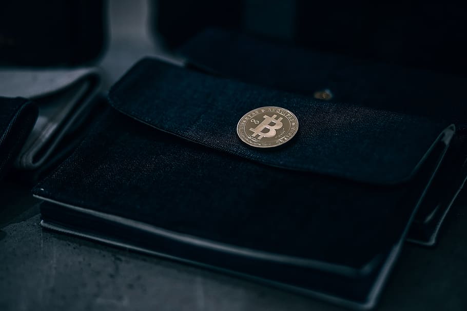Gold-Plated Physical Bitcoin on a Black Wallet Inside a Retail Store., HD wallpaper