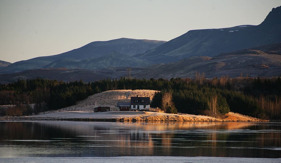 Calm Large Body of Water Across White and Brown House Beside Woods Across Hill HD wallpaper