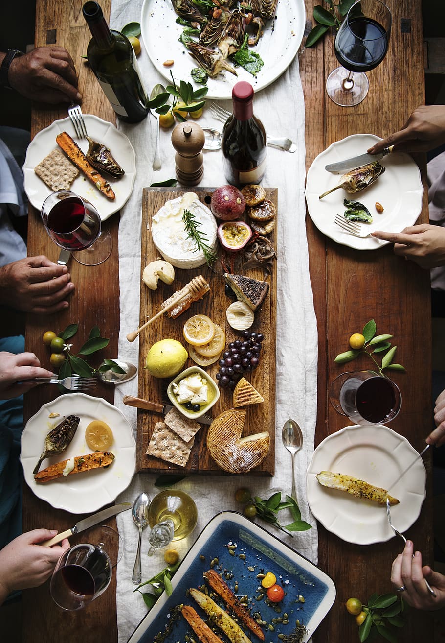Several People Dining on Table, bread, cheese, cheese platter