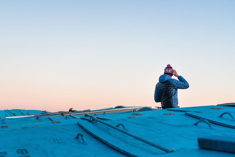 man scratching head on roof top under white sky, winter, cold HD wallpaper